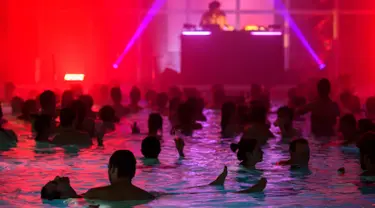 Sejumlah orang menikmati musik DJ Luke Abbott di kolam renang di hotel Cressy selama Festival Antigel (Festival Anti Beku) di Confignon, Jenewa, Swiss (30/1). Festival Antigel ini berlangsung dari 27 Januari-19 Februari 2017. (AFP Photo/Fabrice Coffrini)