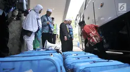 Panitia Penyelenggara Ibadah Haji (PPIH) membantu memindahkan koper milik jemaah haji kloter 2 saat tiba di Asrama Haji Pondok Gede, Rabu (29/8). (Merdeka.com/Iqbal S. Nugroho)