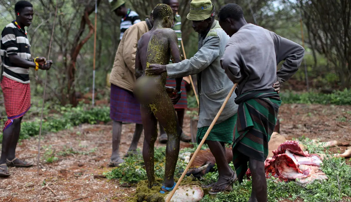 Seorang pria muda Pokot diolesi dengan isi perut dari seekor banteng oleh seorang pemuka untuk menjalani upacara di Baringo County, Kenya , (20/1). Pria dari masyarakat Pokot harus menjalani ritual ini untuk menjadi dewasa. (REUTERS / Siegfried Modola)