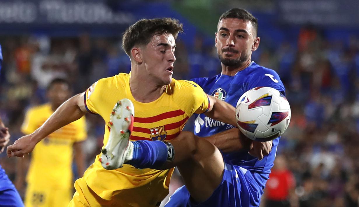 Pemain Barcelona, Gavi (kiri) berebut bola dengan pemain Getafe, Juan Iglesias pada laga pekan pertama Liga Spanyol 2023/2024 di Coliseum Alfonso Perez Stadium, Getafe, Spanyol, 14 Agustus 2023 WIB. (AP Photo/Alvaro Medranda)