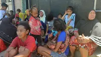 Orang-orang menunggu di luar rumah mereka setelah gempa bumi di Maumere, Indonesia, Selasa (14/12/2021). BMKG menghimbau masyarakat untuk tetap berhati-hati terhadap gempa susulan meskipun status tsunami dengan ancaman waspada telah dicabut. (AP Photo)