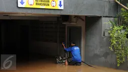 Petugas Damkar PB mengawasi kondisi mesin penyedot air saat melakukan pengeringan di salah satu pertokoan, Jalan Kemang Raya, Jakarta, Minggu (28/8). Dua lokasi parkir bawah tanah pertokoan di kawasan Kemang terendam air. (Liputan6.com/Helmi Fithriansyah)