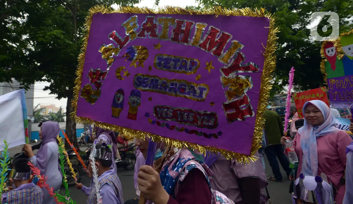 Orangtua murid TK Islam berjalan bersama sambil membawa poster di Jalan Raya Radjiman Widyo Ningrat, Jakarta, Sabtu (26/3/2022). Pawai menyambut datangnya bulan suci Ramadan 1443 Hijriah ini diikuti puluhan murid TK Islam dari berbagai sekolah. (merdeka.com/Imam Buhori)