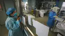 Petugas medis berbicara dengan koleganya yang bekerja di bangsal isolasi Rumah Sakit Jinyintan, Wuhan, Provinsi Hubei, China, Kamis (13/2/2020). Data terbaru tanggal 14 Februari 2020 menunjukkan jumlah korban tewas akibat virus corona mendekati angka 1.500. (Chinatopix Via AP)