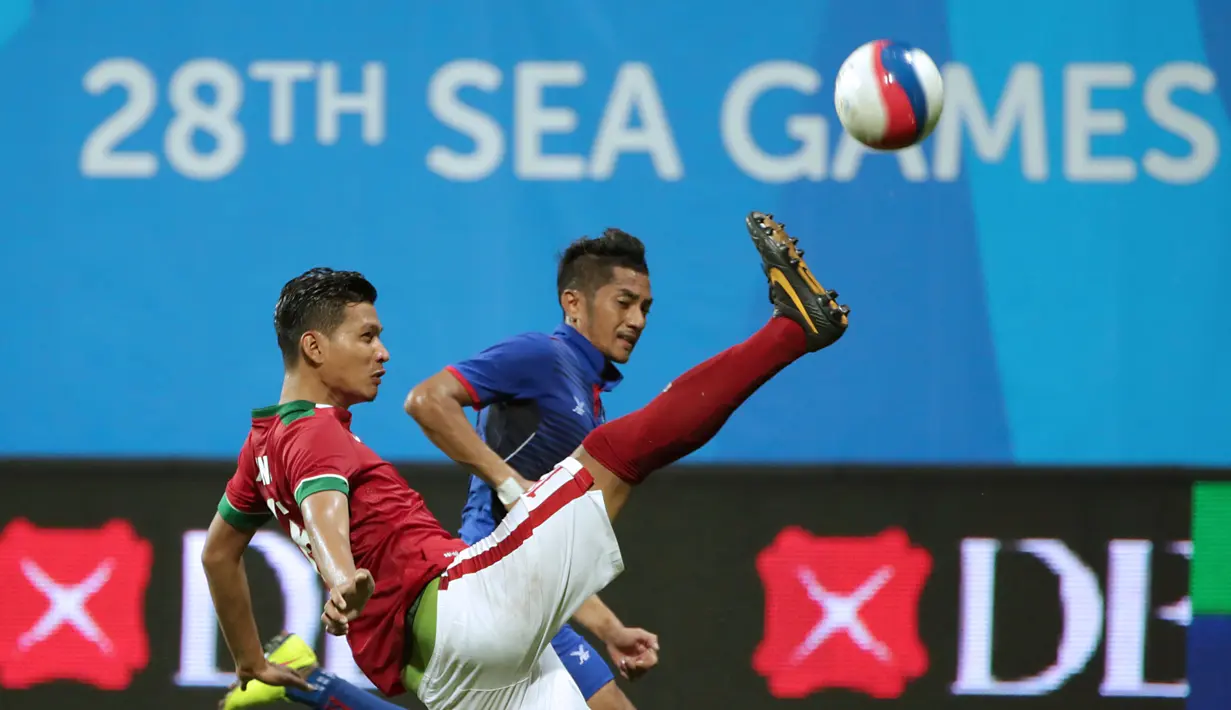 Bek timnas Indonesia U-23, Agung Prasetyo (kiri) membuang bola yang mengarah ke pemain Kamboja di penyisihan Grup A Sea Games 2015 di Stadion Jalan Besar, Singapura, Sabtu (6/6/2015). Indonesia unggul 6-1 atas Kamboja. (Liputan6.com/Helmi Fithriansyah)