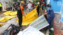 Petugas gabungan menyiapkan kantong jenazah di Puskesmas Carita, Banten, Minggu (23/12). Tim SAR masih melakukan pencarian jenazah yang sebagian besar berasal dari Pantai Carita. (Liputan6.com/Angga Yuniar)