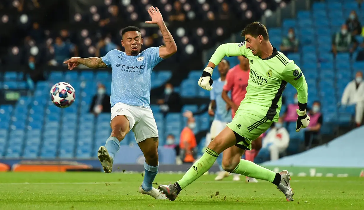 Striker Manchester City, Gabriel Jesus, berebut bola dengan kiper Real Madrid, Thibaut Courtois, pada laga leg kedua 16 besar Liga Champions di Etihad Stadium, Sabtu (8/8/2020) dini hari WIB. Manchester City menang 2-1 atas Real Madrid. (AFP/Peter Powell/pool)