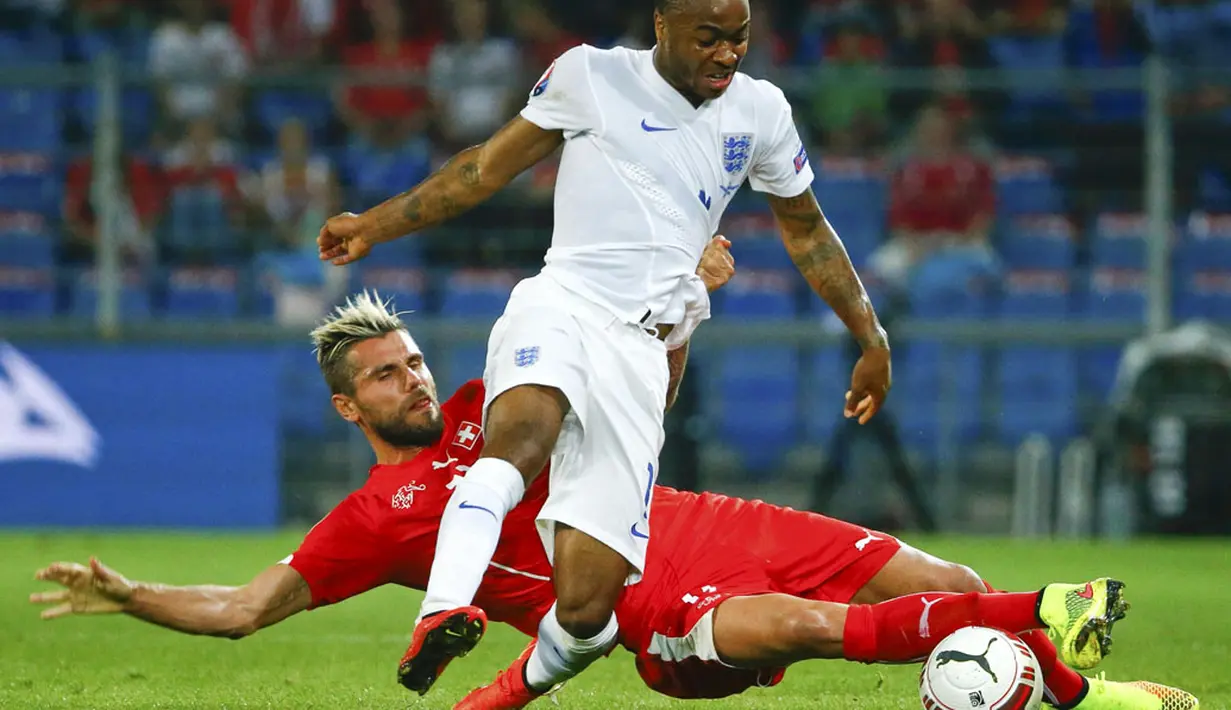 Gelandang Timnas Swiss, Valon Behrami (bawah) mencoba menahan bola dari kaki pemain tengah Inggris, Raheem Sterling, saat berlaga di kualifikasi Euro 2016 di Stadion St Jakob-Park, Basel , (9/9/2014). (REUTERS/Ruben Sprich)