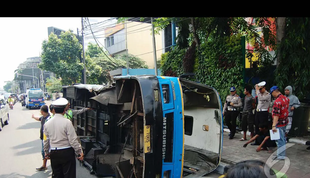 Bus Kopami dalam posisi terguling  di badan jalan, sedangkan busway masih di lokasi kejadian. Petugas pun sudah berdatangangan mengamankan lokasi, Jakarta, Rabu (30/7/2014) (Liputan6.com/Faizal Fanani)