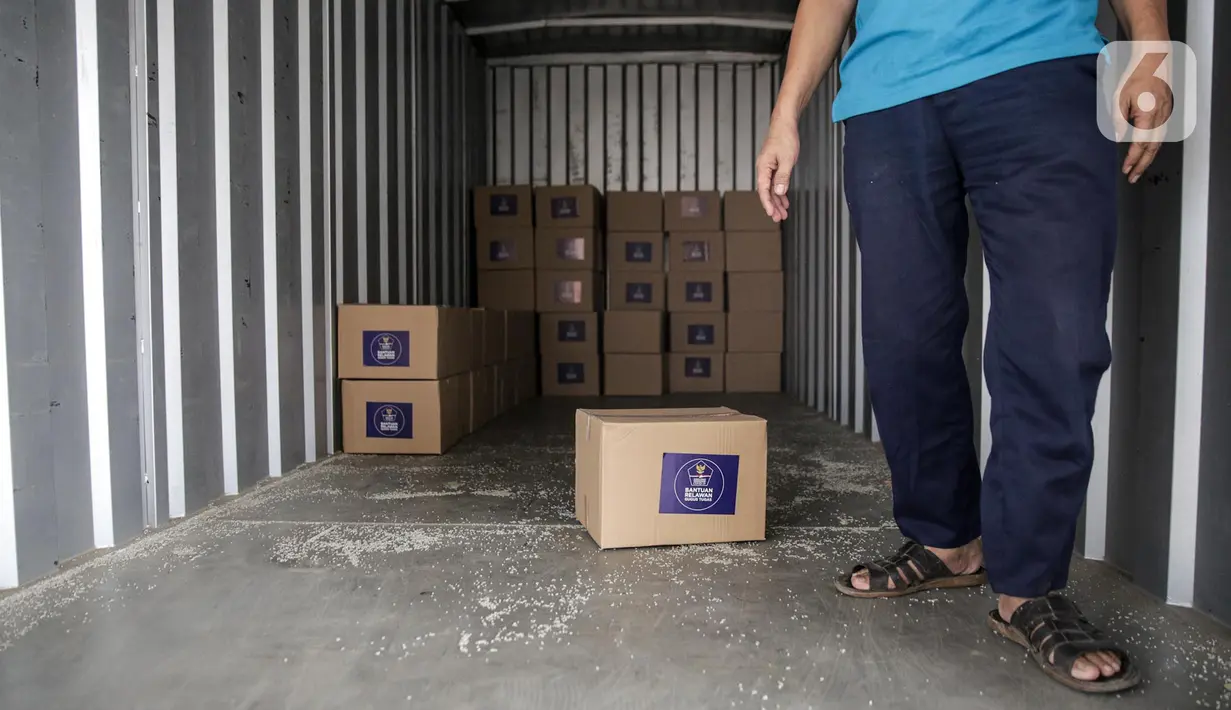 Relawan memindahkan kotak berisi sembako ke dalam truk di GOR Gelanggang Remaja, Jakarta, Senin (18/5/2020). Relawan Gugus Tugas Percepatan Penanganan COVID-19 membagikan 30.000 paket bantuan kepada warga Jabodetabek yang terdampak COVID-19. (Liputan6.om/Faizal Fanani)