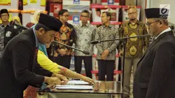 Ketua KPU Arief Budiman (kanan) menyaksikan penandatanganan saat pelantikan anggota KPU Kabupaten/Kota periode 2018-2023 di Gedung KPU RI, Jakarta, Minggu (24/6). (Liputan6.com/Faizal Fanani)