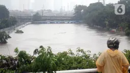 Warga melihat-lihat kondisi Banjir Kanal Barat di Kawasan Tanah Abang, Jakarta, Rabu (1/1/2020). Hujan yang mengguyur Jakarta sejak Selasa sore (31/12/2019) mengakibatkan debit air Banjir Kanal Barat tinggi dan hampir meluap. (Liputan6.com/Helmi Fithriansyah)
