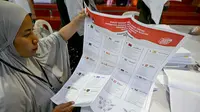 Para staf melipat surat suara pemilihan umum Indonesia 2024 di Gudang Logistik Komisi Pemilihan Umum (KPU) Denpasar, Bali, pada 14 Desember 2023. (SONNY TUMBELAKA/AFP)