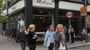 Warga berjalan melewati sebua kedai kopi di London, Inggris, Minggu (17/5/2020). Beberapa restoran, kafe, dan toko katering di Inggris secara bertahap kembali buka setelah pemerintah melonggarkan kebijakan lockdown akibat virus corona COVID-19. (Xinhua/Tim Ireland)