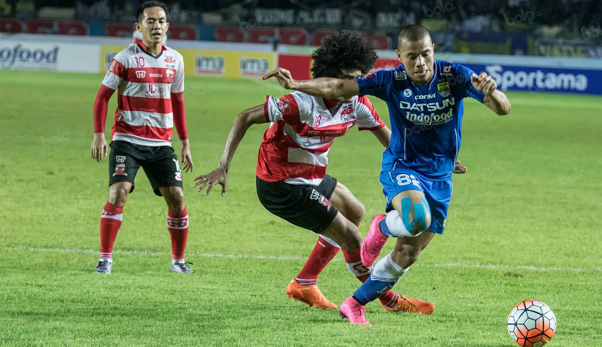Penyerang Persib, Tantan, melewati hadangan gelandang Madura United, Ahmad Maulana, pada laga Torabika Soccer Championship 2016 di Stadion Si Jalak Harupat, Sabtu (28/5/2016). Kedua tim bermain imbang 0-0. (Bola.com/Vitalis Yogi Trisna)