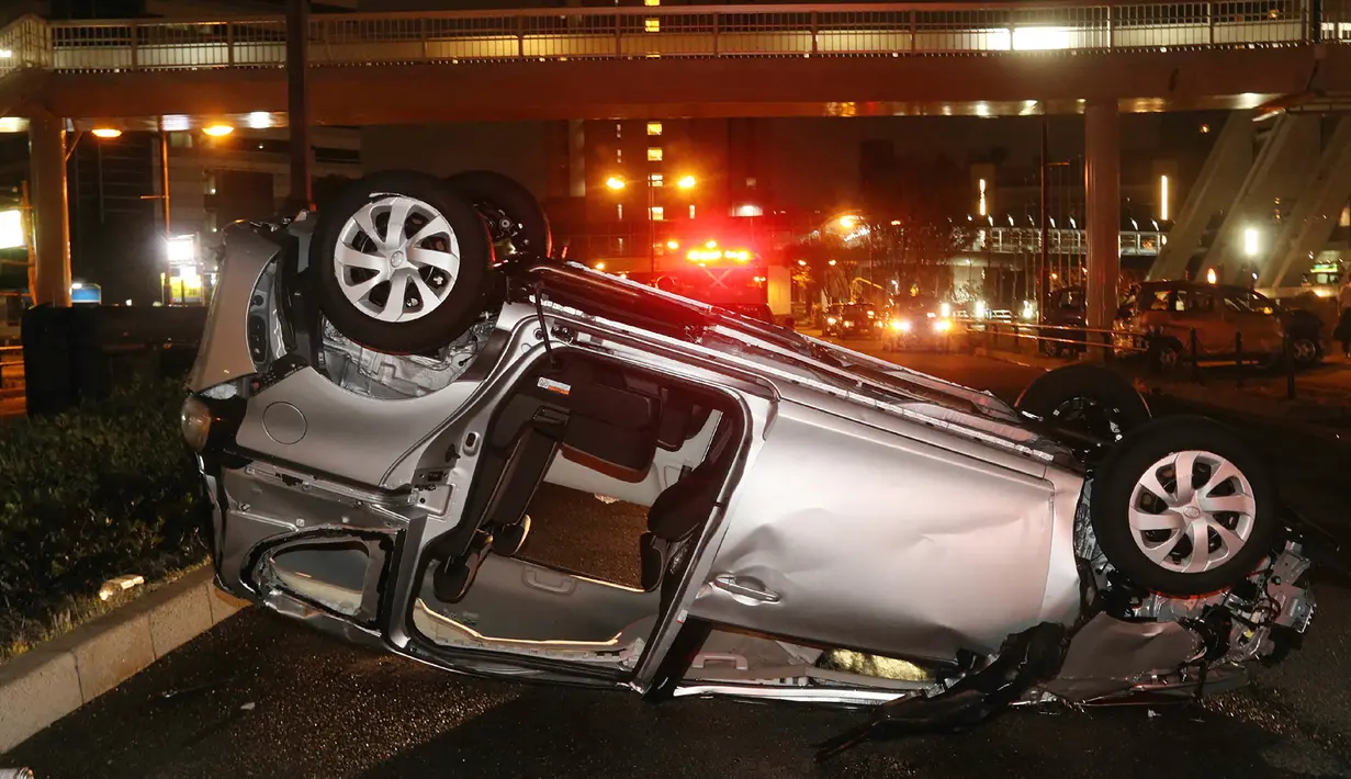 Sebuah mobil terbalik usai dihantam topan Jebi yang melanda Osaka, Jepang, Selasa (4/9). (JIJI PRESS/AFP)
