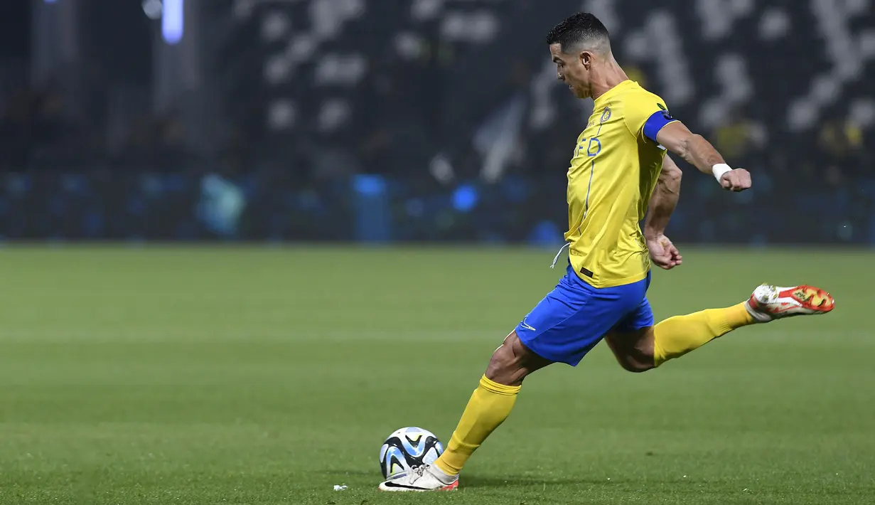 Pemain Al Nassr, Cristiano Ronaldo, menendang bola ke gawang Al Shabab dalam laga perempat final King's Cup Arab Saudi 2023 yang digelar di Al Shabab Club Stadium, Selasa (12/12/2023) dini hari WIB. (AFP/Str)
