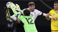 Penyerang Jerman Timo Werner (tengah) berebut bola dengan kiper Ukraina Andrey Pyatov dan bek Ukraina Illia Zabarnyi pada Liga A Grup 4 UEFA Nations League di Red Bull Arena, Minggu (15/11/2020) dinihari WIB. Tertinggal lebih dulu, Jerman mengakhiri laga dengan kemenangan 3-1. (RONNY HARTMANN/AFP)