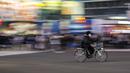 Seorang pengendara sepeda yang mengenakan masker melintasi persimpangan Shibuya Tokyo, Jepang, Senin (29/11/2021). Jepang tetap mengizinkan orang asing yang memiliki izin tinggal untuk memasuki Negeri Sakura tersebut. (AP Photo/Kiichiro Sato)