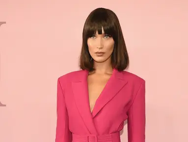 Model Bella Hadid berpose saat tiba dalam acara CFDA Fashion Awards di Manhattan, New York, (5/6). Model 20 tahun ini tampil cantik dan seksi mengenakan jaket dengan ikat pinggang berwarna pink. (Dimitrios Kambouris/Getty Images North America/AFP)