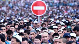 Rambu lalu lintas terlihat di antara ratusan muslim Rusia yang tengah melaksanakan salat Idul Fitri di luar masjid di pusat kota Moskow, Selasa (5/7). Perayaan Idul Fitri 1437 H di Rusia jatuh pada hari ini. (Kirill KUDRYAVTSEV/AFP)