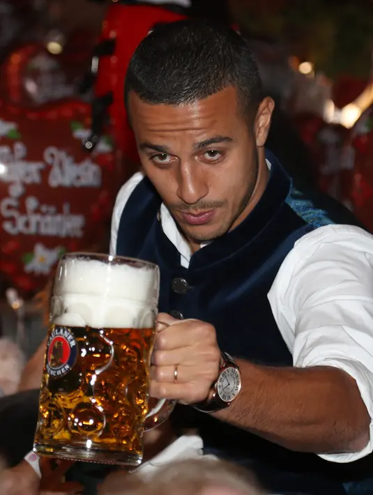 Gelandang Bayern Munchen, Thiago Alcantara berpose dengan bir selama kunjungan tahunan klub sepak bola di festival bir Oktoberfest di Munich, Jerman selatan pada 6 Oktober 2019. (AFP.Stefan Matzke)