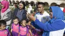 Pemain Persib, Muhammad Taufiq melakukan selfie bersama anak-anak SD usai latihan di Alun-alun Kota Bandung, Jawa Barat, Kamis (10/9/2015). (Bola.com/Vitalis Yogi Trisna)