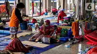 Aktivitas warga korban banjir Cipinang Melayu saat mengungsi di Masjid Universitas Borobudur, Jakarta, Minggu (21/2/2021). Sebanyak 60 orang warga dari RW 04 Kelurahan Cipinang Melayu mengungsi karena permukimannya terendam banjir akibat luapan air Kali Sunter. (Liputan6.com/Faizal Fanani)