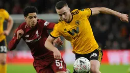 Pemain Liverpool, Ki-Jana Hoever merebut bola dari pemain  Wolverhampton Wanderers, Diogo Jota pada laga putaran ketiga Piala FA di Molineux Stadium, Senin (7/1). Liverpool tersingkir dari Piala FA setelah takluk 1-2 dari Wolverhampton. (AP/Rui Vieira)