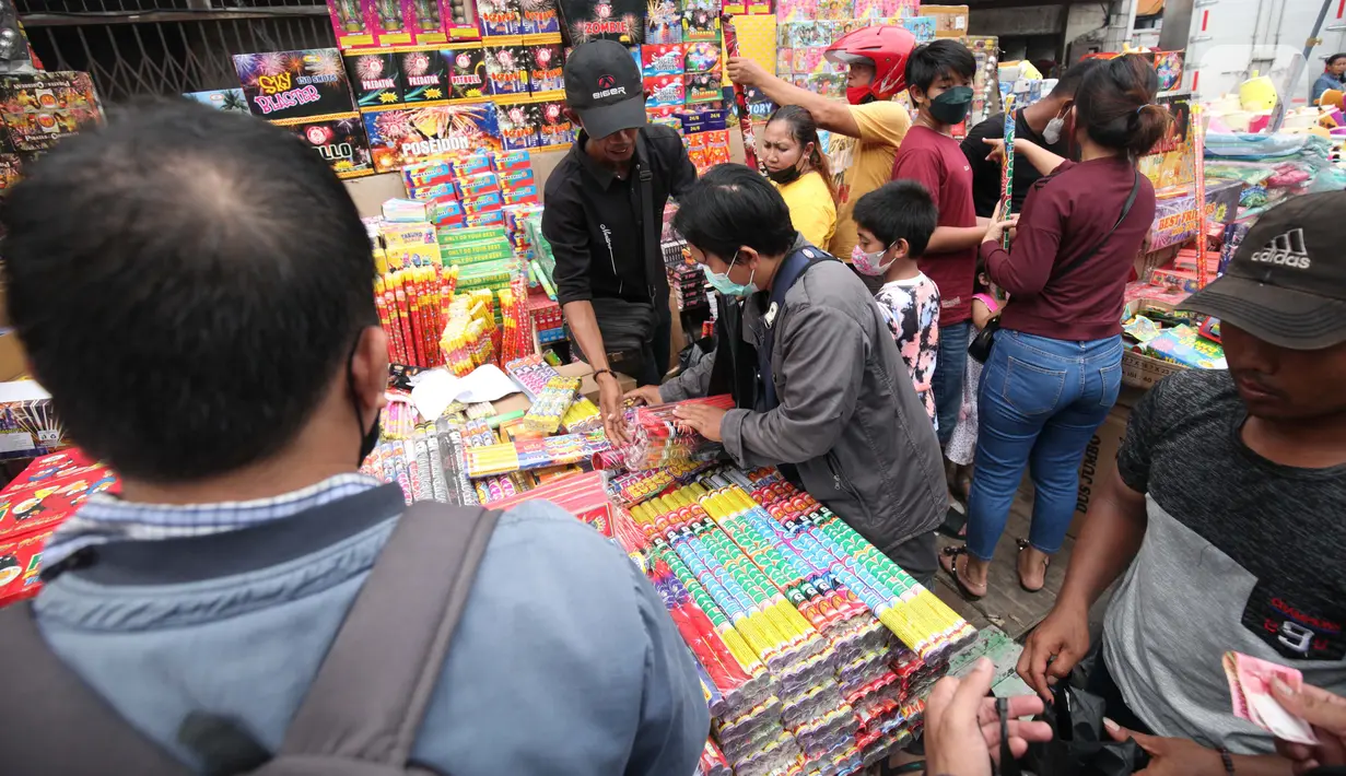 Warga memilih kembang api yang dijajakan oleh pedagang di Pasar Asemka, Jakarta, Kamis (30/12/2021). Meski Larangan Tahun Baru 2022 diberlakukan untuk membatasi mobilitas, namun masih banyak warga yang berburu kembang api baik untuk dijual maupun digunakan sendiri. (Liputan6.com/Johan Tallo)