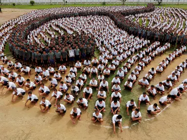 Para narapidana membentuk formasi angka sembilan Thailand untuk menghormati mendiang Raja Thailand Bhumibol Adulyadej di penjara Pathum Thani, Bangkok, Thailand (27/10). Raja Bhumibol juga dikenal sebagai Raja Rama IX. (Reuters/Chaiwat Subprasom)