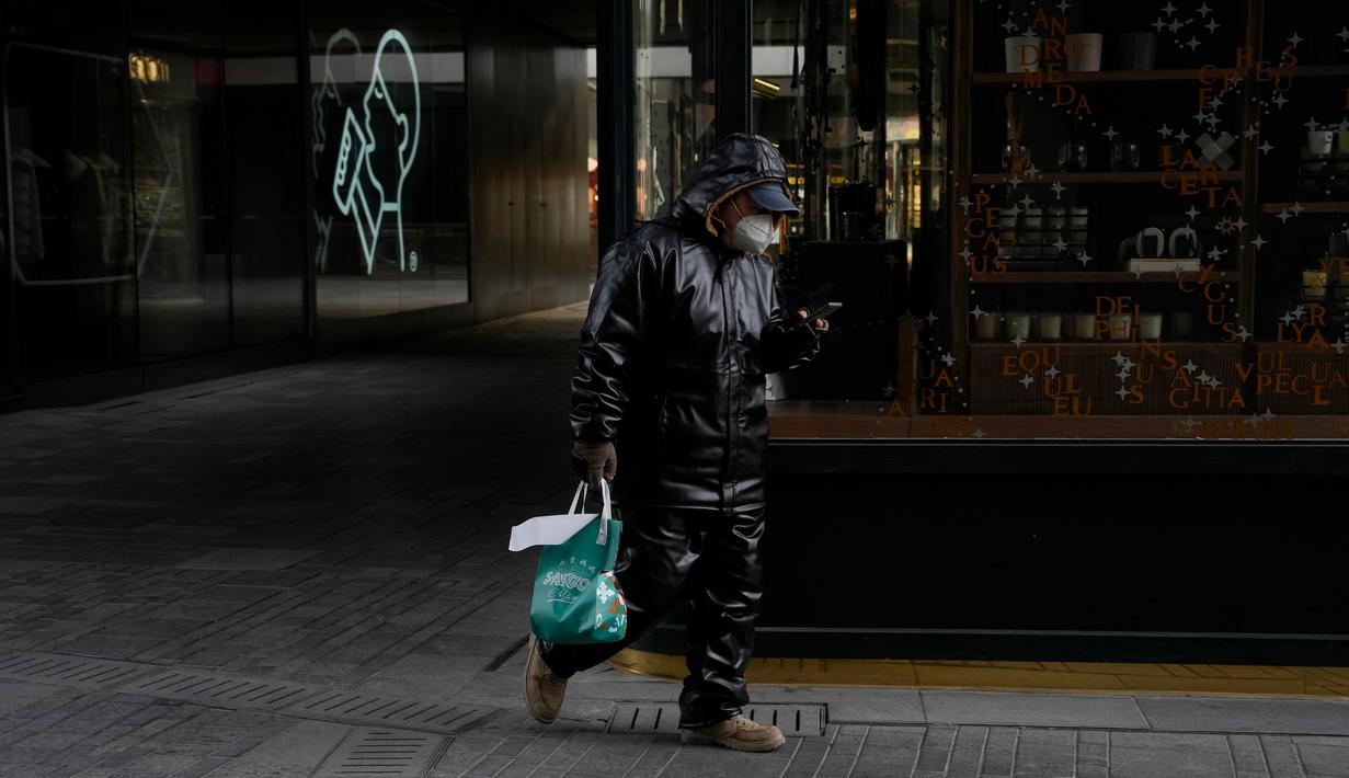 Seorang kurir berjalan melewati toko-toko yang tutup di sebuah mal di Beijing, China, Kamis (15/12/2022). Seminggu setelah China melonggarkan beberapa tindakan pengendalian COVID-19 yang paling ketat di dunia, ketidakpastian masih ada mengenai arah pandemi di negara dengan jumlah penduduk terpadat di dunia tersebut. (AP Photo/Ng Han Guan)