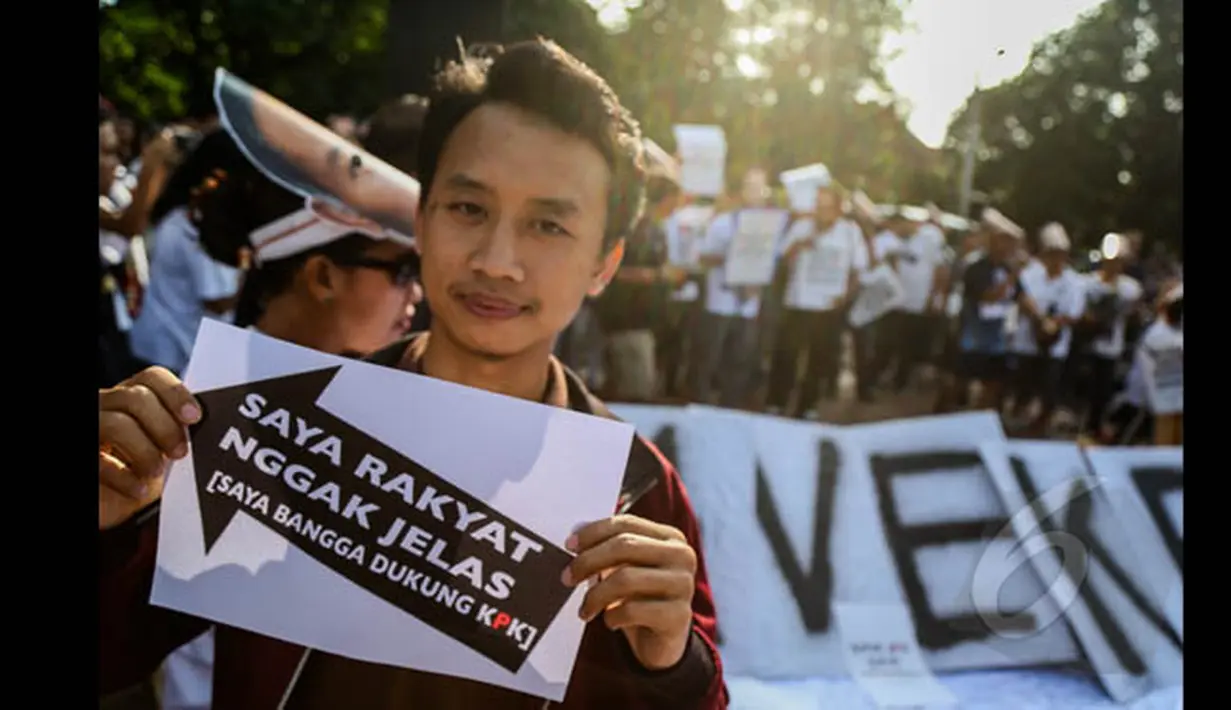 Seorang aktivis membawa atribut bertuliskan "Saya Rakayat Ngga Jelas [Saya Bangga Dukung KPK] saat menggelar aksi di kawasan Jalan Sudirman, Jakarta, Minggu (25/1/2015). (Liputan6.com/Faizal Fanani)