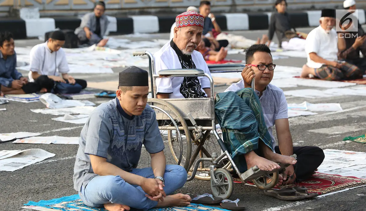 Seorang kakek duduk di kursi roda bersama kerabat usai menjalankan Salat Idul Adha 1438 H di kawasan Pasar Senen, Jakarta, Jumat (1/8). Setelah menjalankan salat umat muslim melakukan penyembelihan hewan kurban. (Liputan6.com/Immanuel Antonius)
