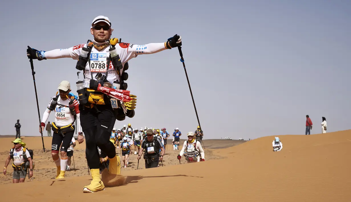 Seorang peserta marathon terlihat bersemangat saat kejuaraan marathon des Sables di Maroko Selatan, (10/4). Marathon des Sables kali ini merupakan gelaran yang ke-31. (AFP PHOTO/JEAN-PHILIPPE Ksiazek)
