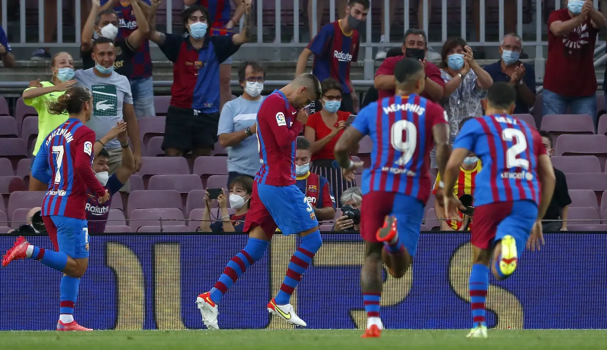 Bek Barcelona, Gerard Pique (tengah) berselebrasi usai mencetak gol ke gawang Real Sociedad pada pertandingan La Liga Spanyol di stadion Camp Nou di Barcelona, Spanyol, Senin (16/8/2021). Barcelona menang atas Sociedad 4-2.  (AP Photo/Joan Monfort)