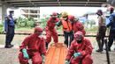 Petugas mengenakan APD saat mengevakuasi korban banjir yang terpapar Covid-19 dalam simulasi penanganan banjir di Kalimalang, Cipinang Melayu, Rabu (17/11/2021). Simulasi digelar dalam rangka kesiapsiagaan petugas dalam penanganan korban banjir.  (merdeka.com/Iqbal S Nugroho)