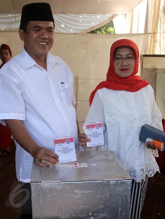 Calon Walikota Tangerang Selatan nomor urut 2 Arsid dan istri memasukan surat suara ke kotak saat menggunakan hak pilih di TPS 31 Kelurahan Pondok Benda, Tangsel, Rabu (9/12). Arsid merupakan pemilih perdana pada TPS tersebut. (Liputan6.com/Fery Pradolo)