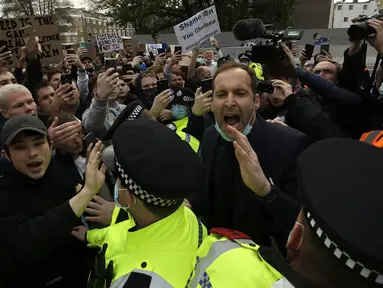 Mantan kiper Chelsea, Petr Cech (kanan) mencoba menenangkan para fans yang melakukan unjuk rasa atas keputusan klub yang ikut menyetujui dibentuknya Liga Super Eropa di luar Stadion Stamford Bridge, London, Selasa (20/4/2021). (AP/Matt Dunham)