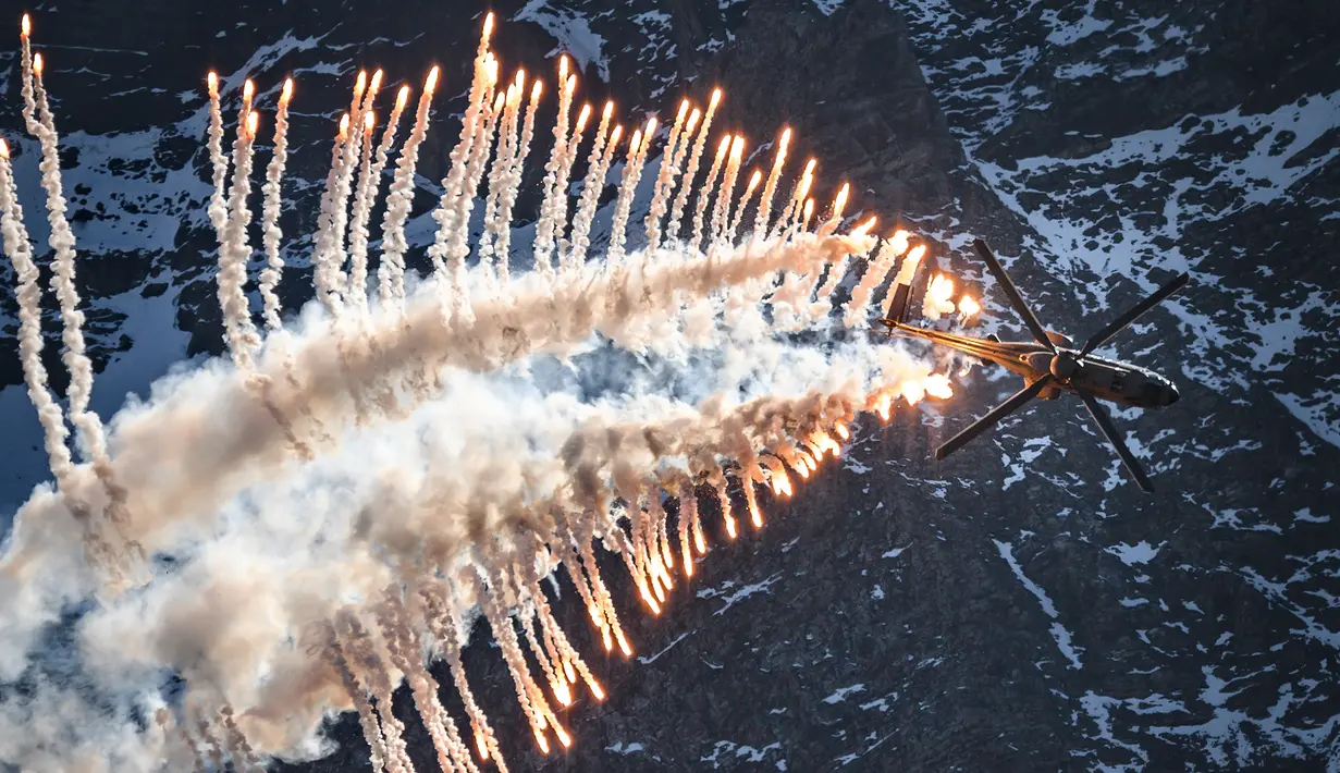 Helikopter Super Puma Cougar melakukan atraksi mengeluarkan "flare" atau suar selama demonstrasi penerbangan Angkatan Udara Swiss di Axalp, 10 Oktober 2018. (Photo by Fabrice COFFRINI / AFP)