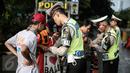 Petugas kepolisian merazia  suporter yang membawa barang berbahaya disekitar kawasan Gelora Bung Karno, Jakarta, Minggu (8/5/2016).Persija akan melawan Semen Padang pada lanjutan Torabika Soccer Championship 2016. (Liputan6.com/Faizal Fanani)