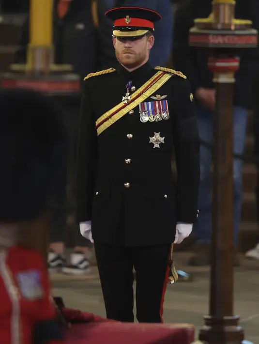 Pangeran Harry ditugaskan untuk berjaga di sekitar peti jenazah Ratu Elizabeth II di Westminster Hall, di Istana Westminster, London, Sabtu (17/9/2022). Pangeran Harry dan istrinya, Meghan Markle membuat keputusan mengejutkan dengan mundur sebagai anggota senior Kerajaan Inggris pada Januari 2020. (Chris Jackson/Pool Photo via AP)