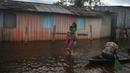 Seorang ibu membawa putrinya menuju sekolah di jalan yang tergenang banjir oleh naiknya sungai Negro di Iranduba, negara bagian Amazonas, Brasil, Senin (23/5/2022). Wilayah Amazon sedang dilanda banjir dengan 35 kotamadya yang menghadapi salah satu banjir terburuk mereka dalam beberapa tahun dan permukaan air diperkirakan akan meningkat selama beberapa bulan mendatang. (AP Photo/Edmar Barros)