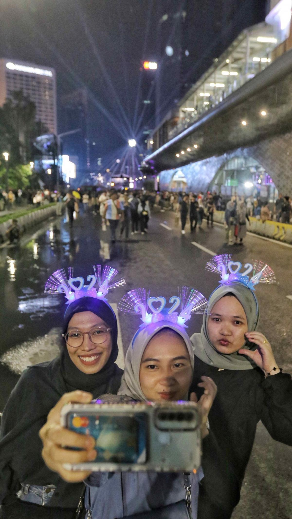 Warga berfoto selfie saat menikmati suasana "Malam Muda Mudi" di Bundaran HI.