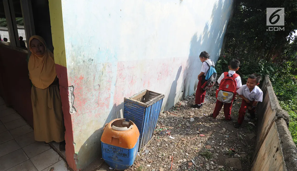Murid-murid buang air kecil di pojokan sekolah di SDN Kertajaya 2, Rumpin, Bogor, Senin (22/7/2019). Sudah lebih dari tiga tahun mereka belajar  pada fasilitas yang minim. (merdeka.com/Arie Basuki)