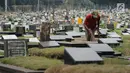 Petugas membersihkan makam di TPU Tanah Kusir, Jakarta, Selasa (29/8). Suku Dinas Kehutanan DKI Jakarta berencana memperluas area TPU Tanah Kusir sebesar 1,9 hektare. (Liputan6.com/Helmi Fithriansyah)