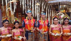 Dua pembalap MotoGP dari tim Honda, Luca Marini dan Joan Mir, tengah mempelajari kebudayaan Bali dalam kunjungannya ke Pulau Dewata, Senin (2/3/2026). Keduanya antuias mengikuti berbagai aktivitas tradisional bersama masyarakat. (Bola.com/Gregah Nurikhsani)