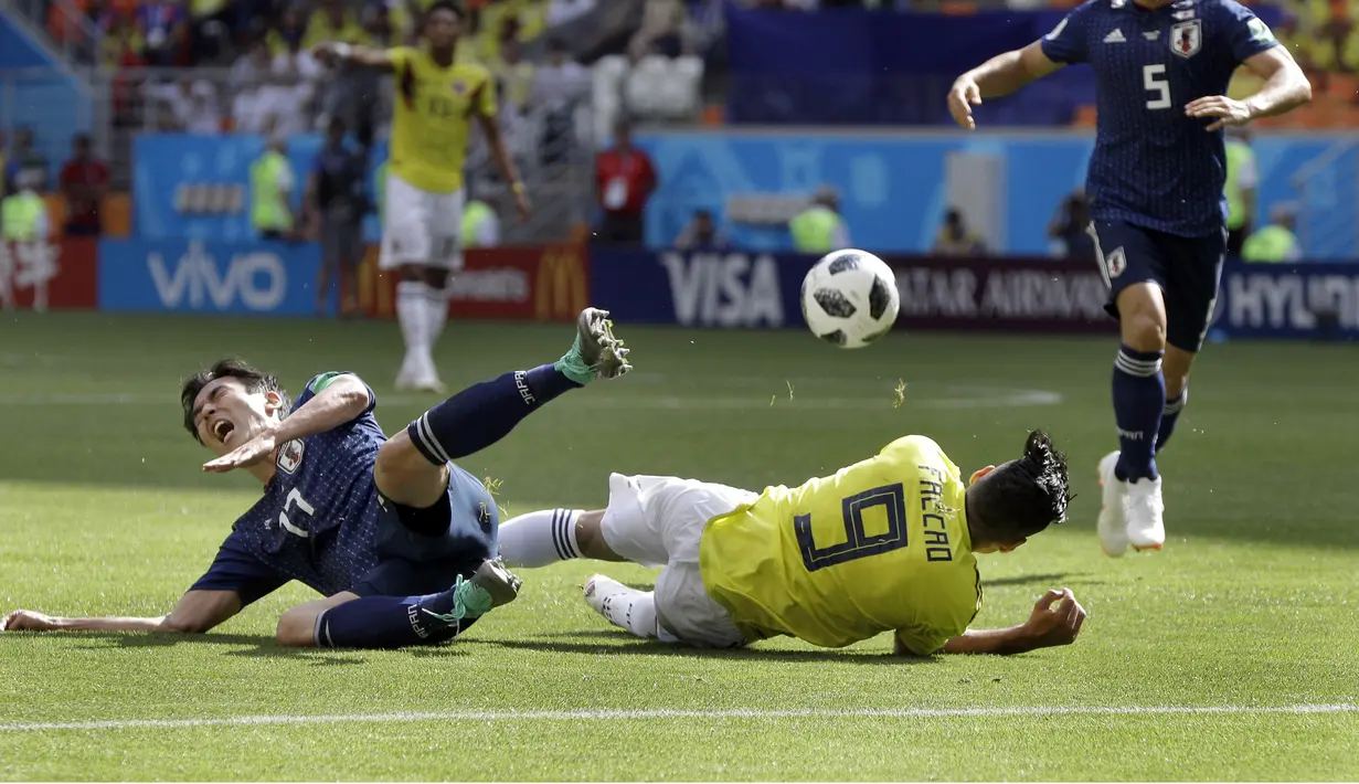 Pemain Jepang, Makoto Hasebe (kiri) dan pemain Kolombia, Radamel Falcao jatuh saat berebut bola pada laga grup H Piala Dunia 2018 di Mordavia Arena, Saransk, Rusia, (19/6/2018). Jepang menang 2-1. (AP/Mark Baker)