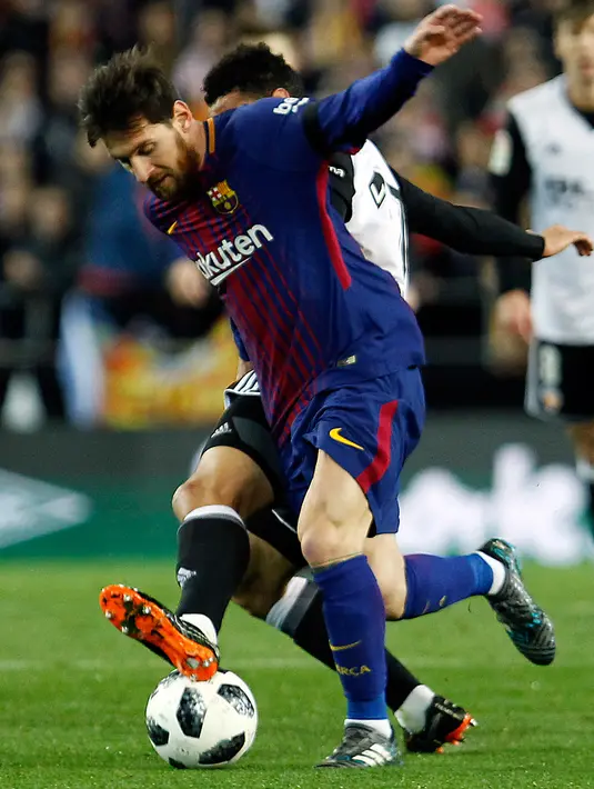 Striker Barcelona Lionel Messi berebut bola dengan pemain Valencia Francis Coquelin saat pertandingan Copa del Rey di stadion Mestalla di Valencia (8/2). (AP Photo/Alberto Saiz)