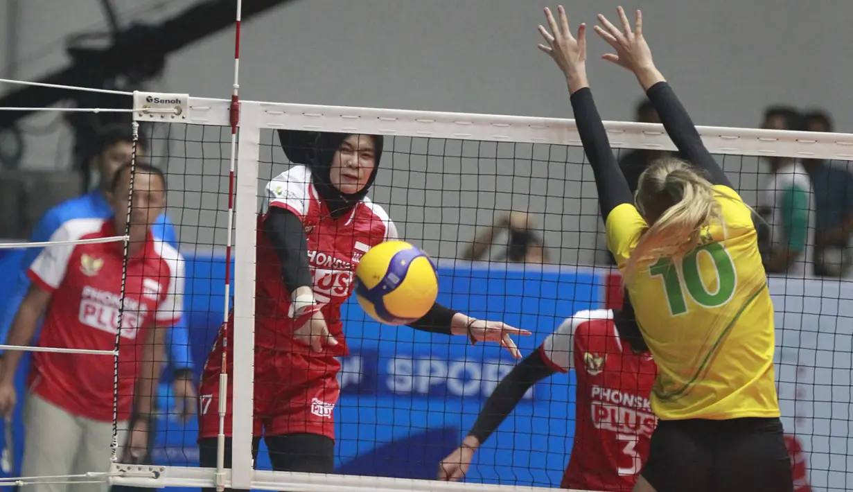 Pemain timnas bola voli putri Indonesia, Wilda Siti Nurfadhilah (kiri) melepaskan spike yang berusaha diblok pemain Australia, Kasey Hogan pada laga lanjutan Grup E babak Delapan Besar Kejuaraan Bola Voli Putri Asia AVC Challenge Cup 2023 di GOR Tri Dharma, Gresik, Jawa Timur, Rabu (21/6/2023) malam WIB. Indonesia menang 3-0 (25-13, 25-17, 25-16) dan dipastikan lolos ke semifinal. (Dok. PBVSI)